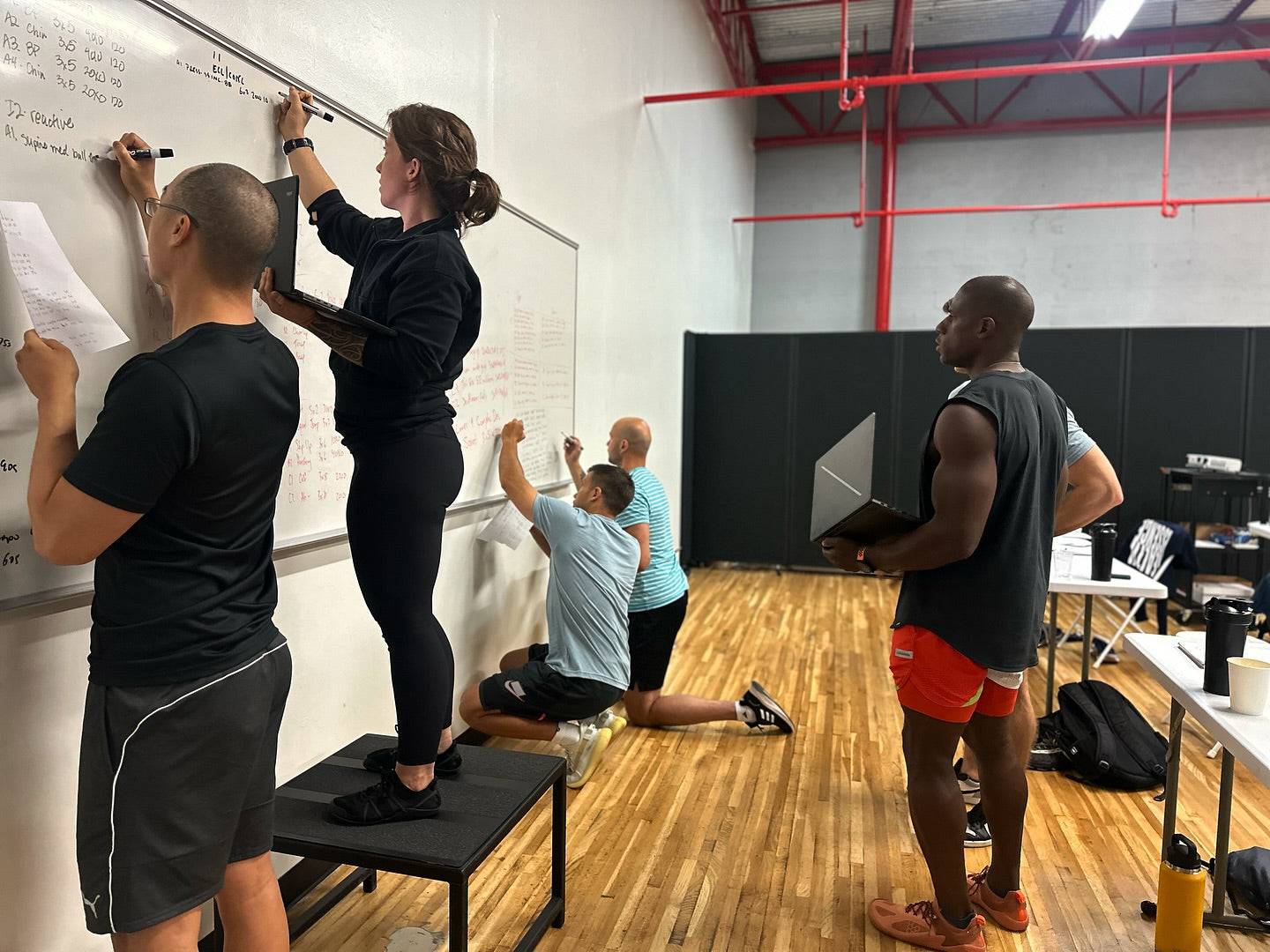 Trainer designing strength-based workout plans for clients